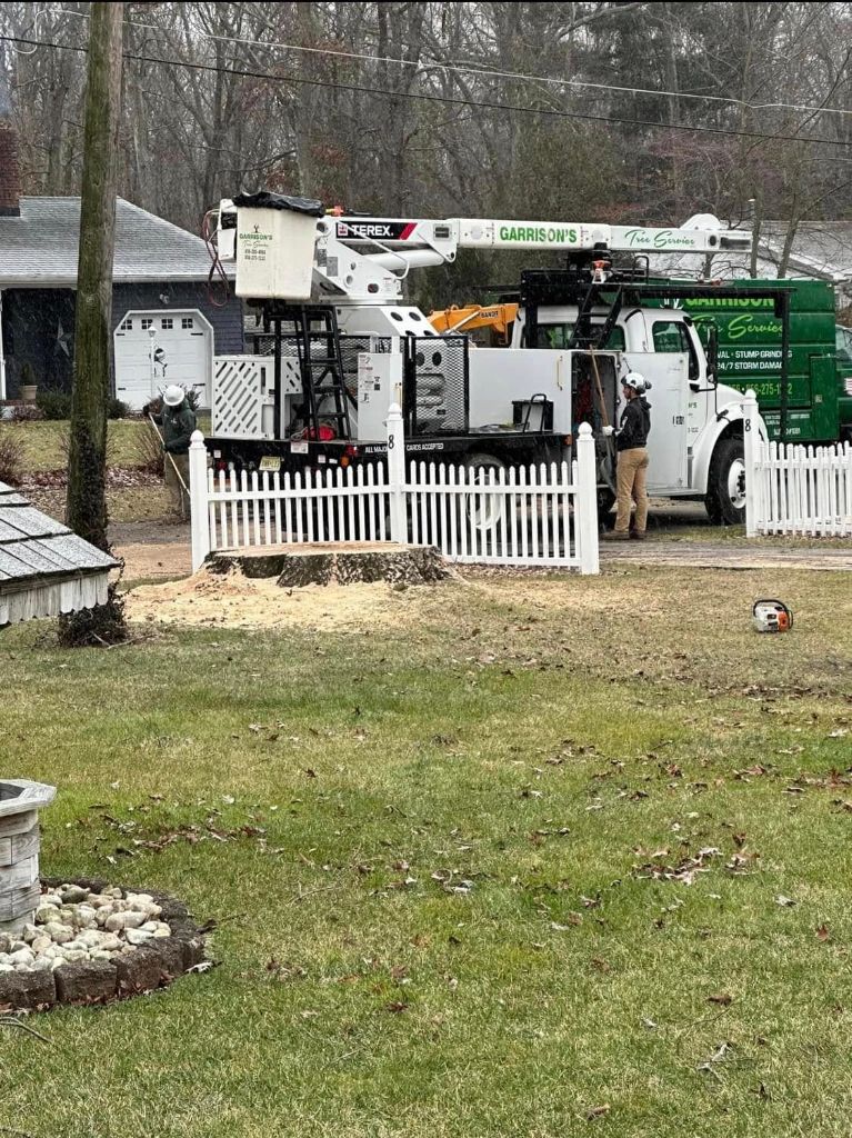 Garrison's Tree Service bucket truck at a residential property removing a stump