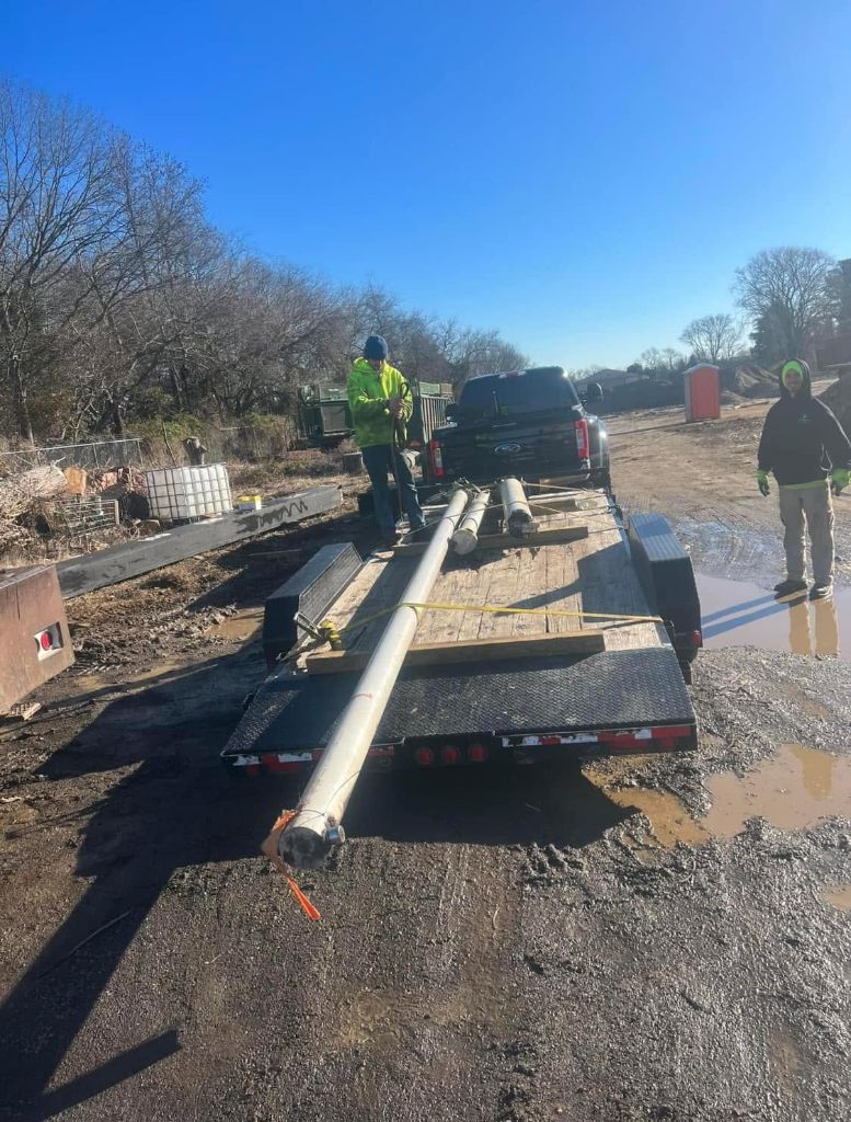 Garrison's Tree Service crew loading equipment onto a trailer for transport