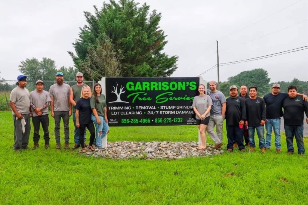 Garrison's Tree Service current crew standing together in front of company sign